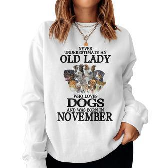 Never Underestimate An Old Lady Who Loves Dogs Born November Women Sweatshirt | Mazezy