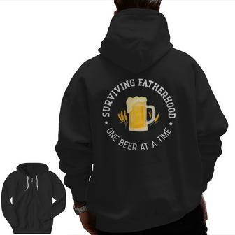 Mens Father's Day Surviving Fatherhood One Beer At A Time Zip Up Hoodie Back Print | Mazezy