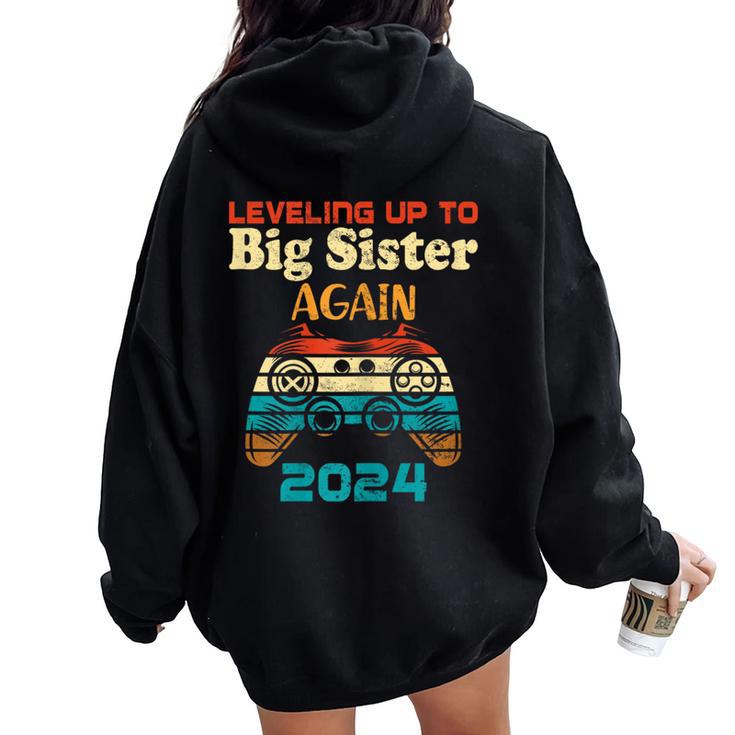 Retro Leveling Up To Big Sister Again 2024 Baby Announcement Women Oversized Hoodie Back Print